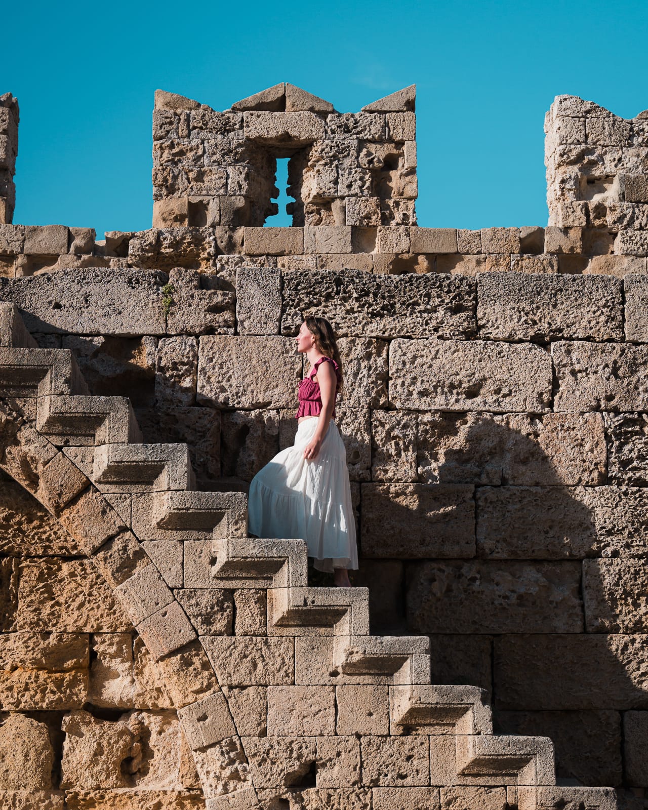 woman walking up stone staircase at Saint Paul’s Gate, Rhodes