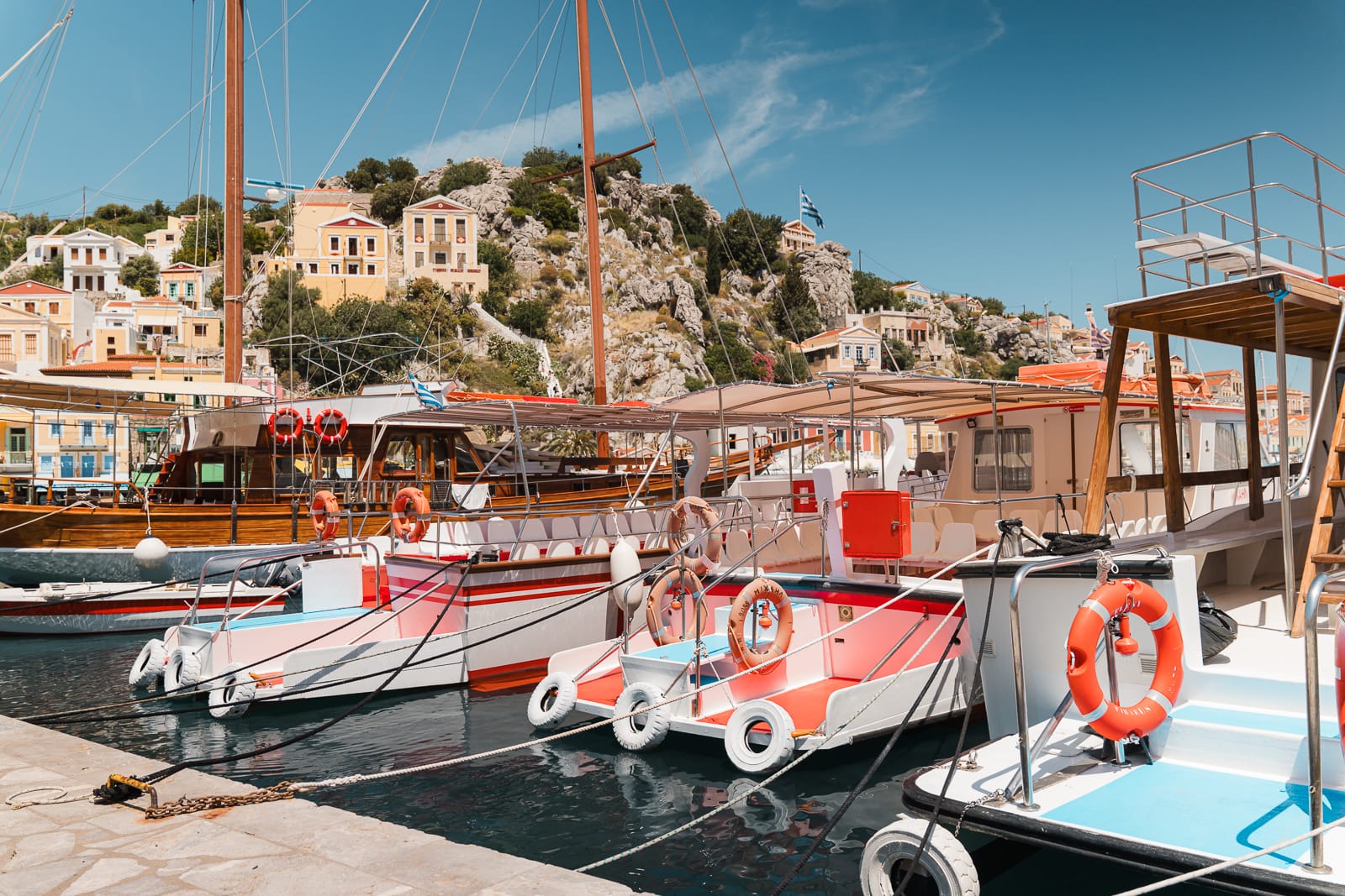 colourful pinka and blue boats at symi island harbour, greece