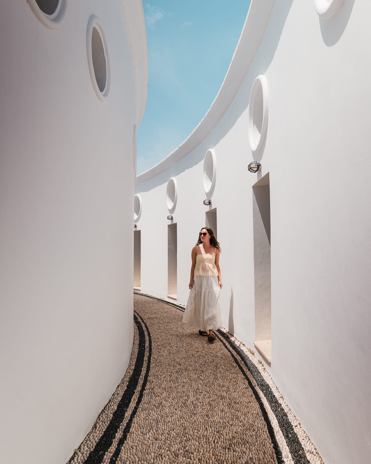 woman walking though white-washed alleyway at Kalithea Springs, Rhodes