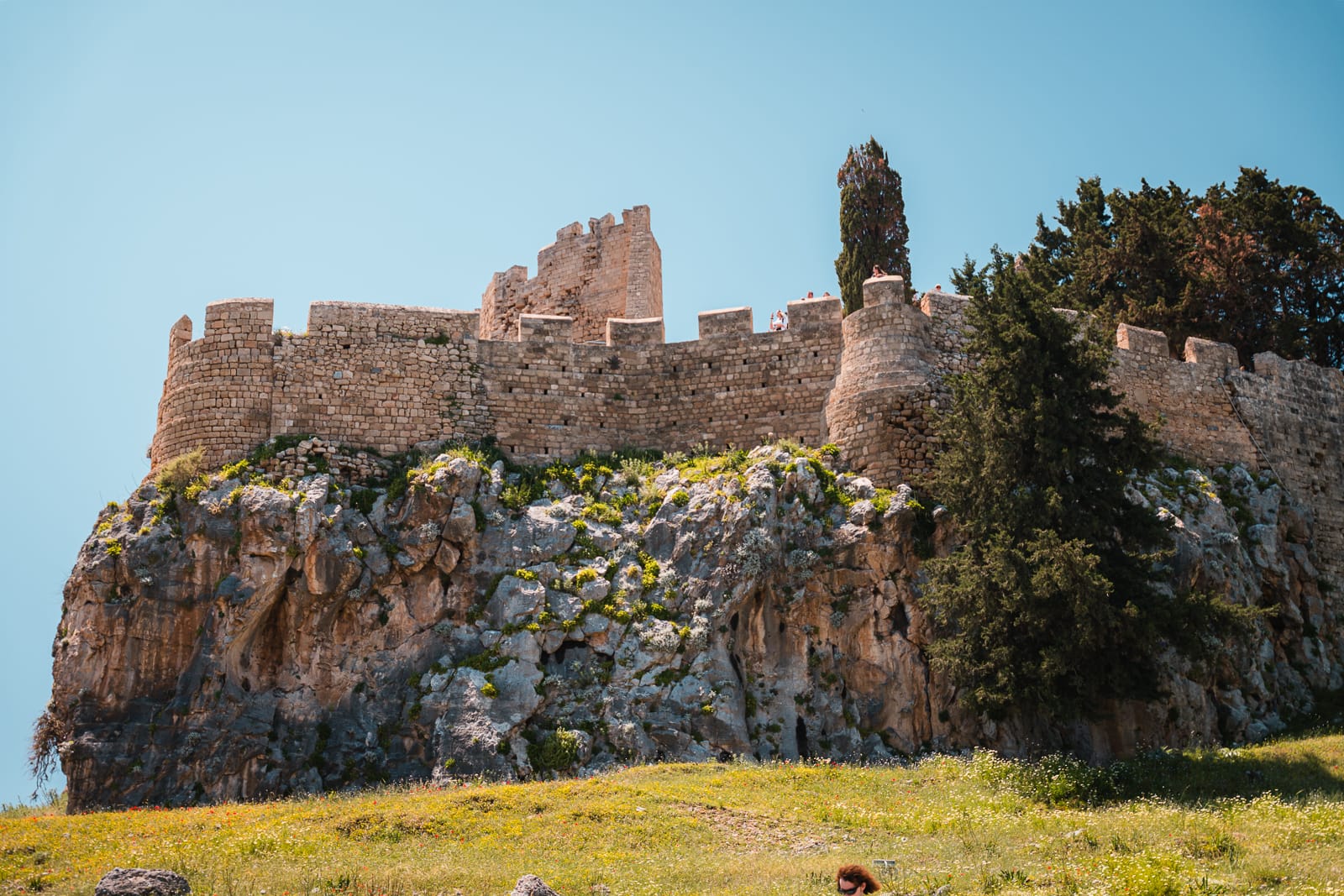 lindos acropolis surrounded by green grass and trees
