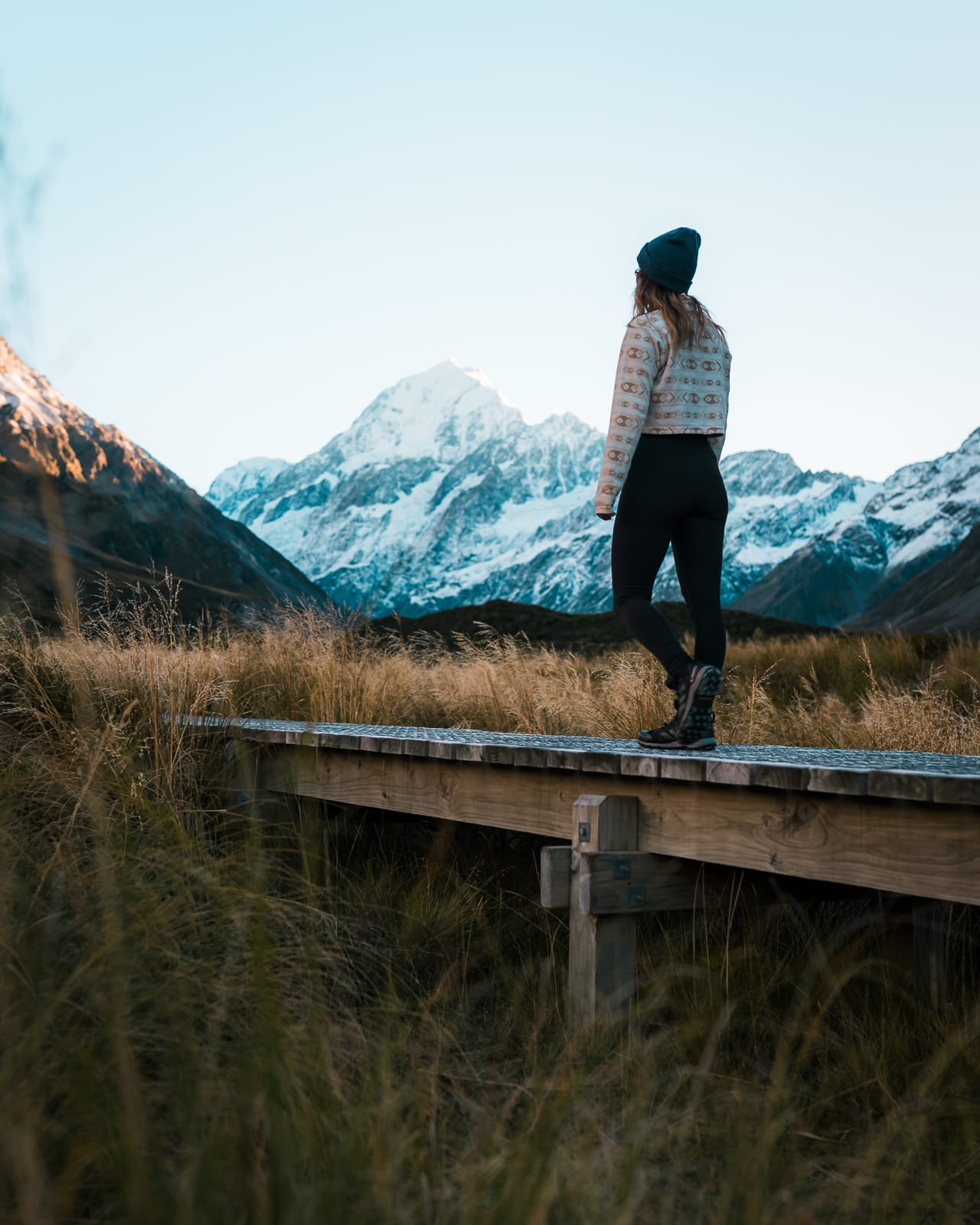 woman walking on boardwalk on hooker valley track, mt cook national park