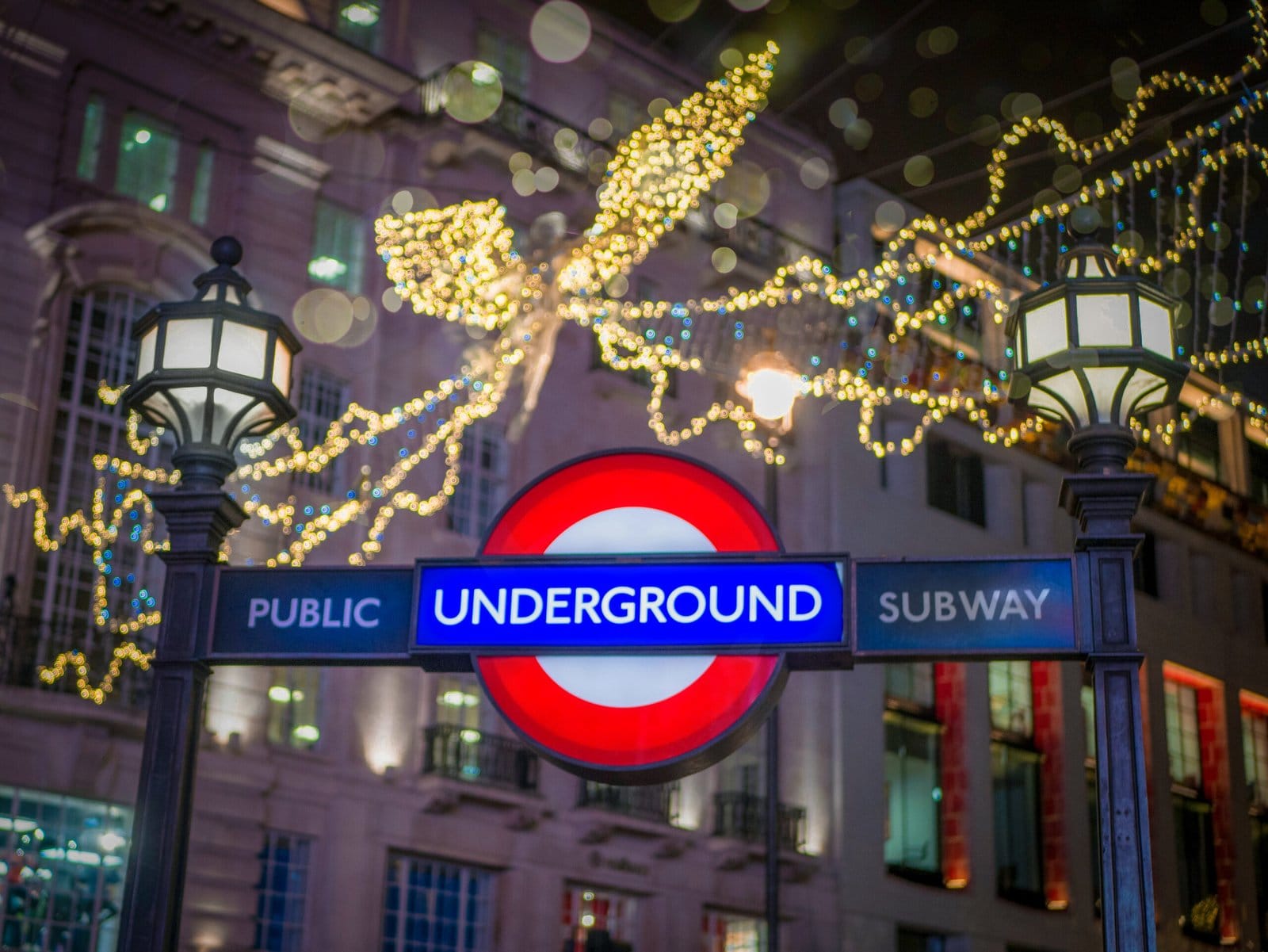 london underground sign with christmas fairy lights in background