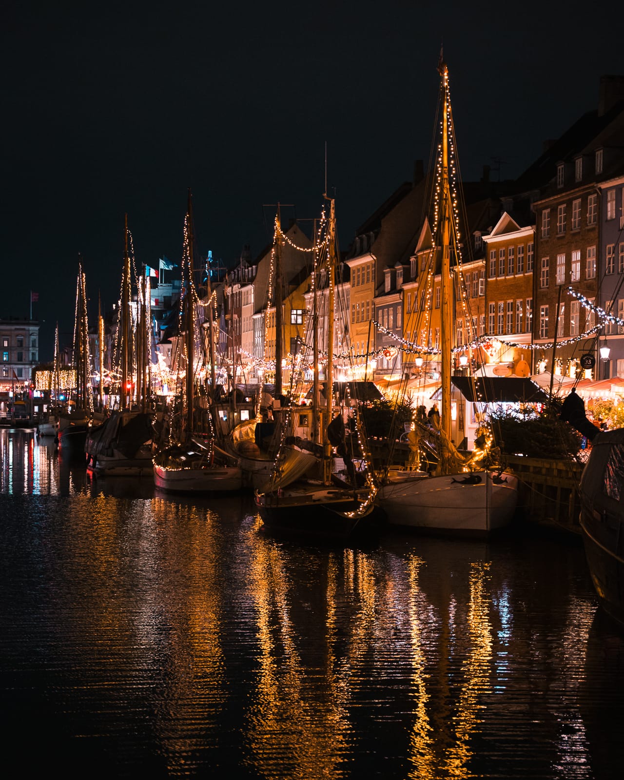 twinkling lights on boats reflecting into the water at Nyhavn, Copenhagen