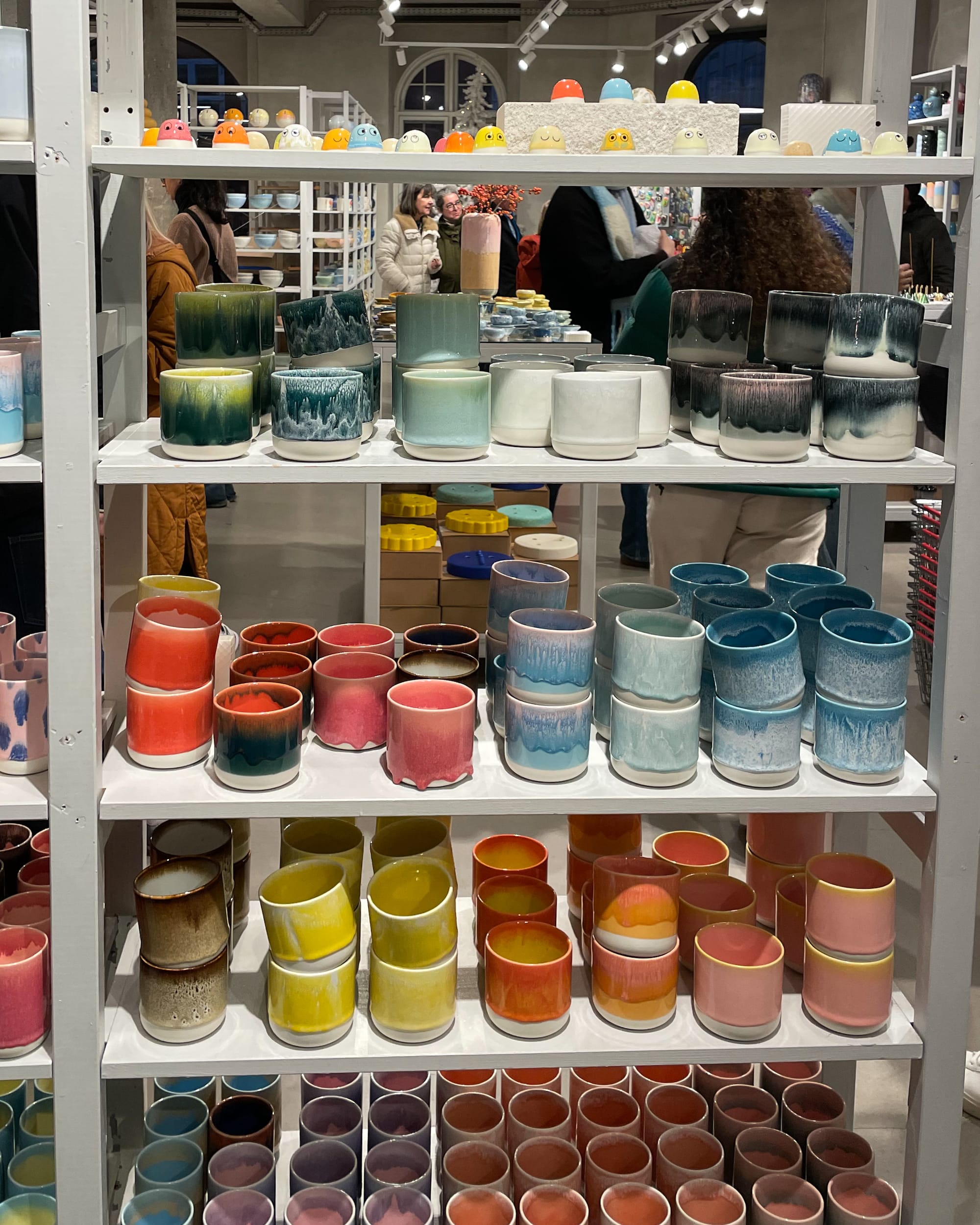 colourful ceramic mugs on a shelf