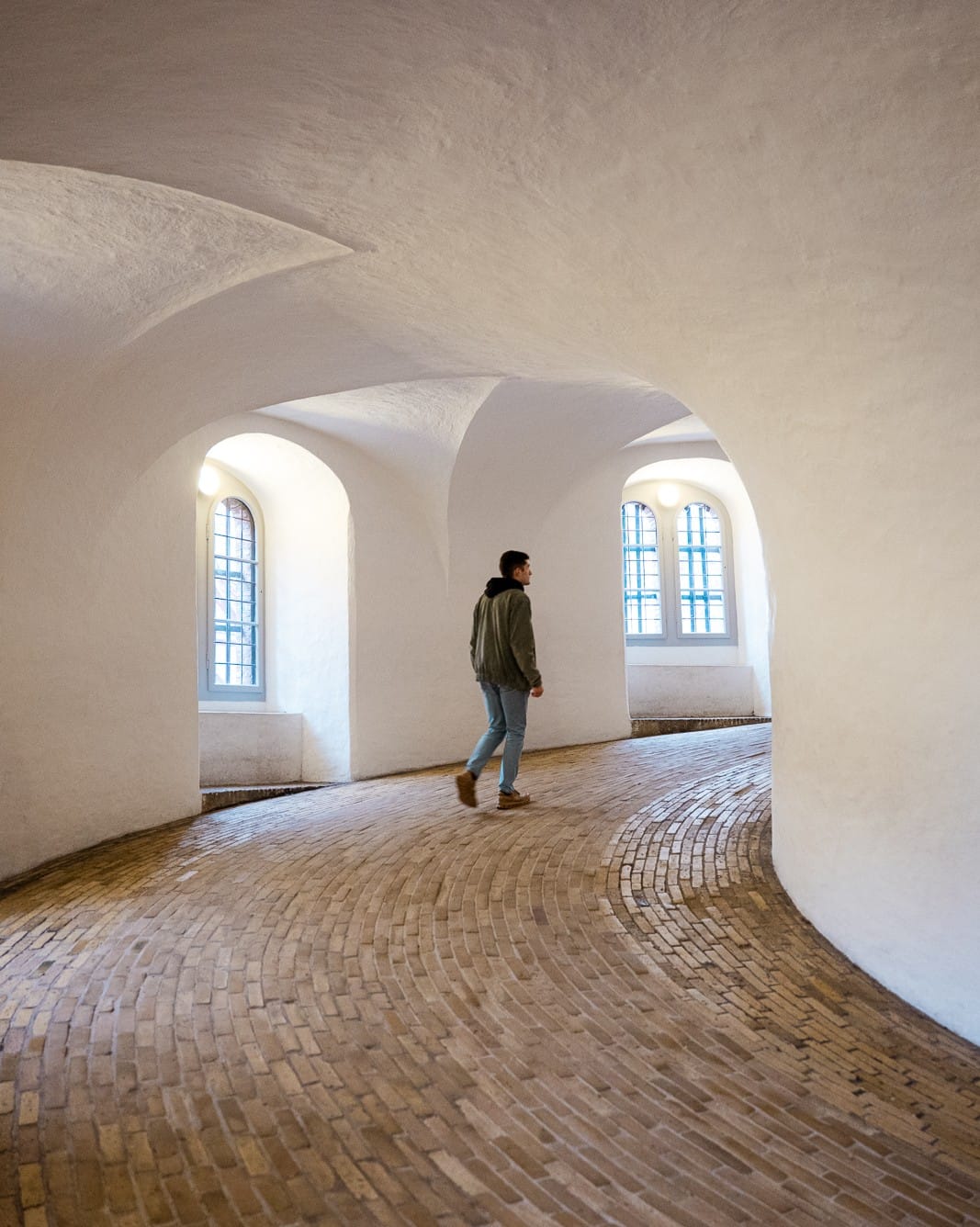 man walking up curved tower - round tower, copenhagen