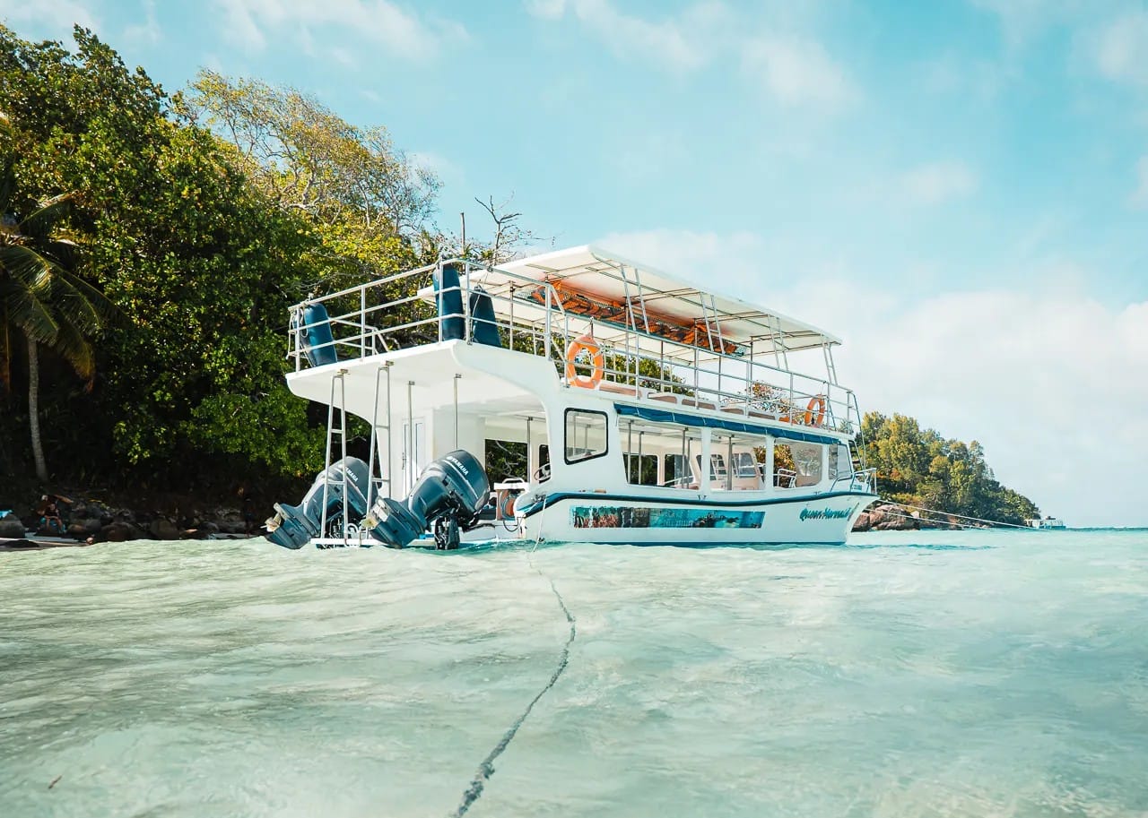 white boat floating on turqoise water in Saint-Anne Marine Park, seychelles