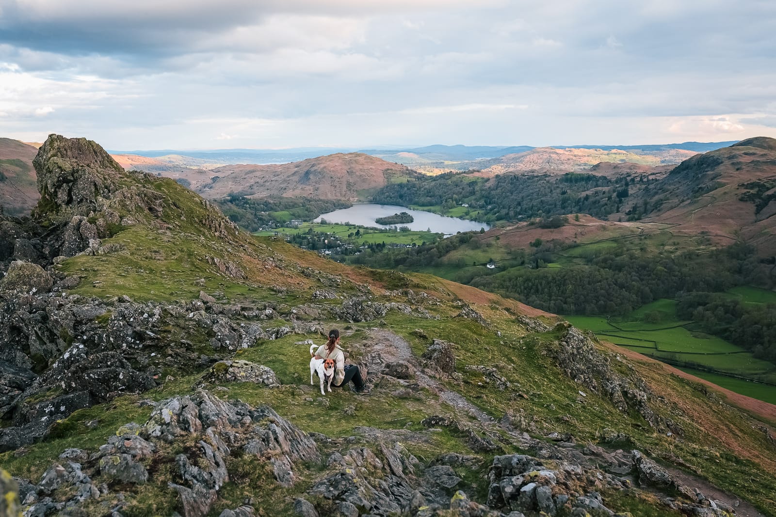 woman sitting on the mountain top of Helm Cra in the lake district